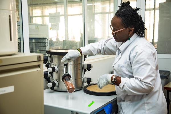 EC CHINA: setting up a freeze dryer for drying tannin extract Black female scientist in a lab