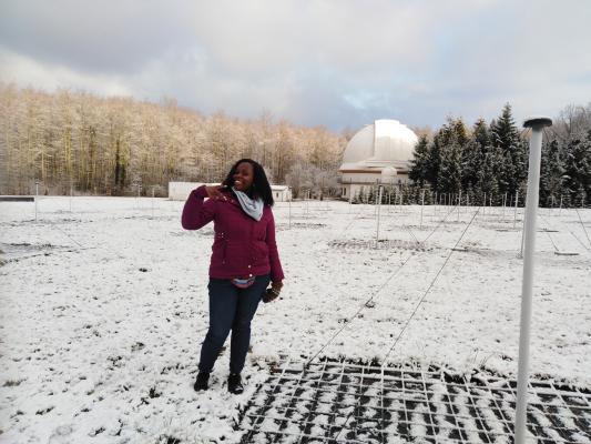 EC fellow, Priscilla Muheki, physicist from Uganda: pictured during a research stay at a snowy observatory station Woman in a snowy landscape with an observation tower in the background