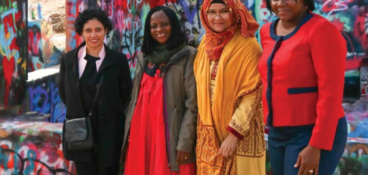2025 OWSD - Elsevier Foundation Awardees pose for a photograph against a grafitti-covered wall