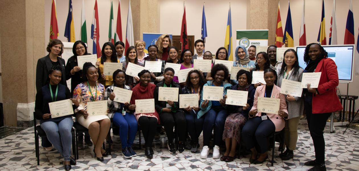 A group of women scientists pose for group photo holding certificates